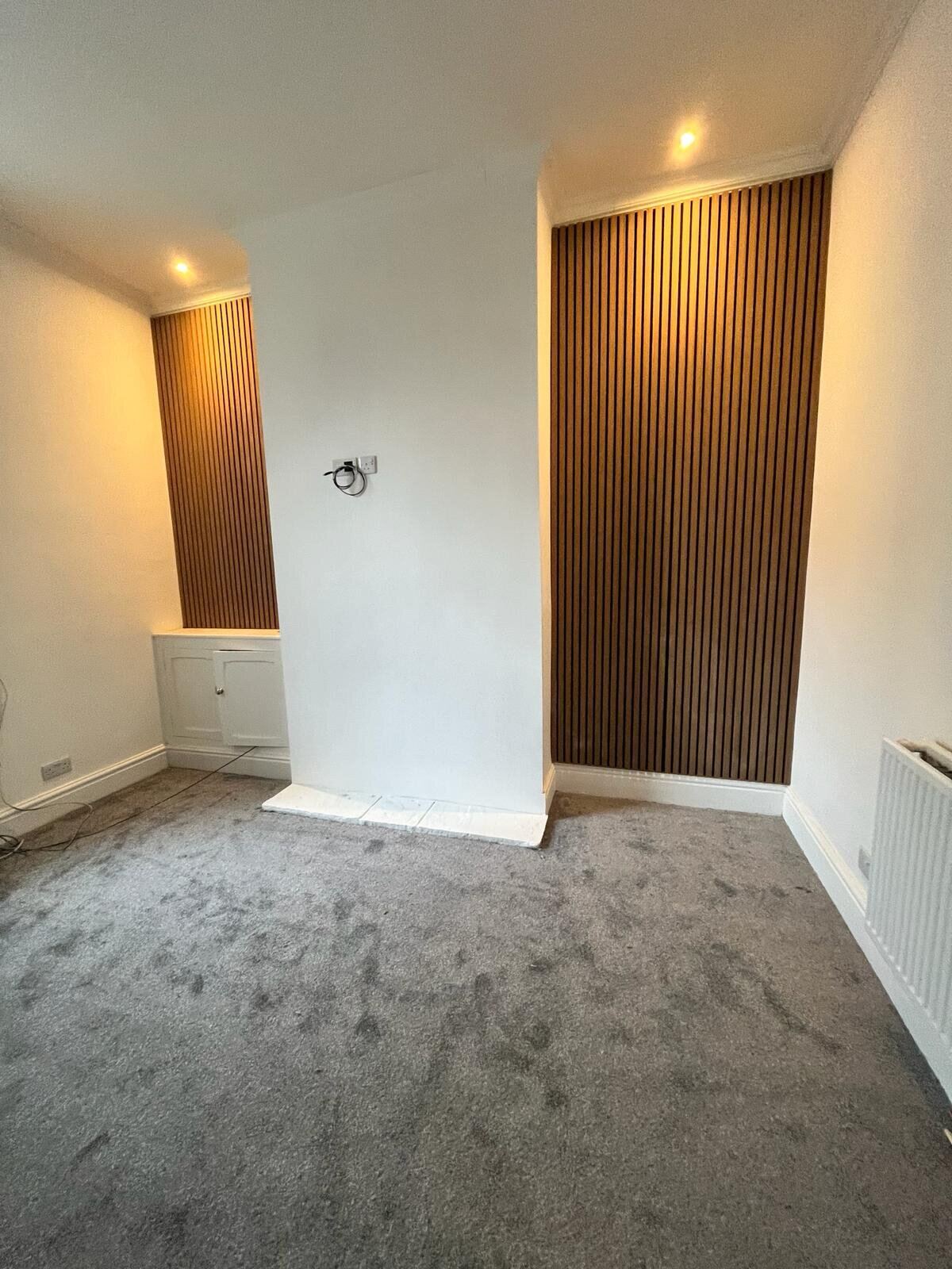 Acoustic wood slat feature wall with concealed LED downlighting in a Fylde Coast home